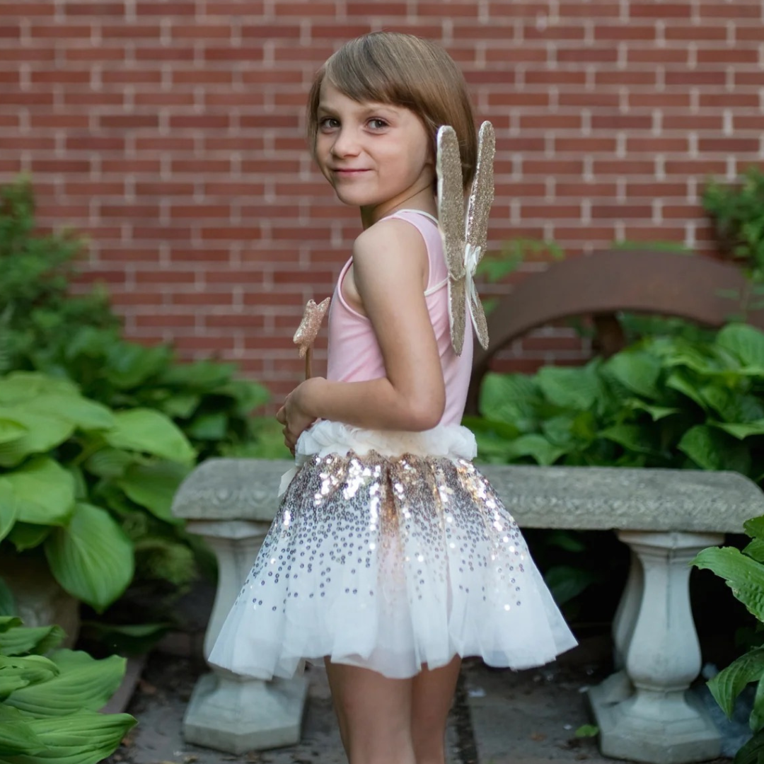 Falda de lentejuelas doradas con alas y varita