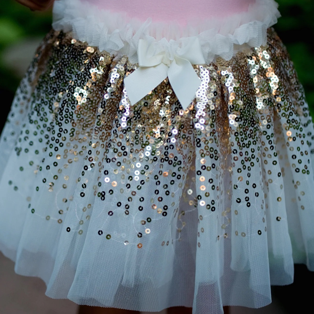 Falda de lentejuelas doradas con alas y varita