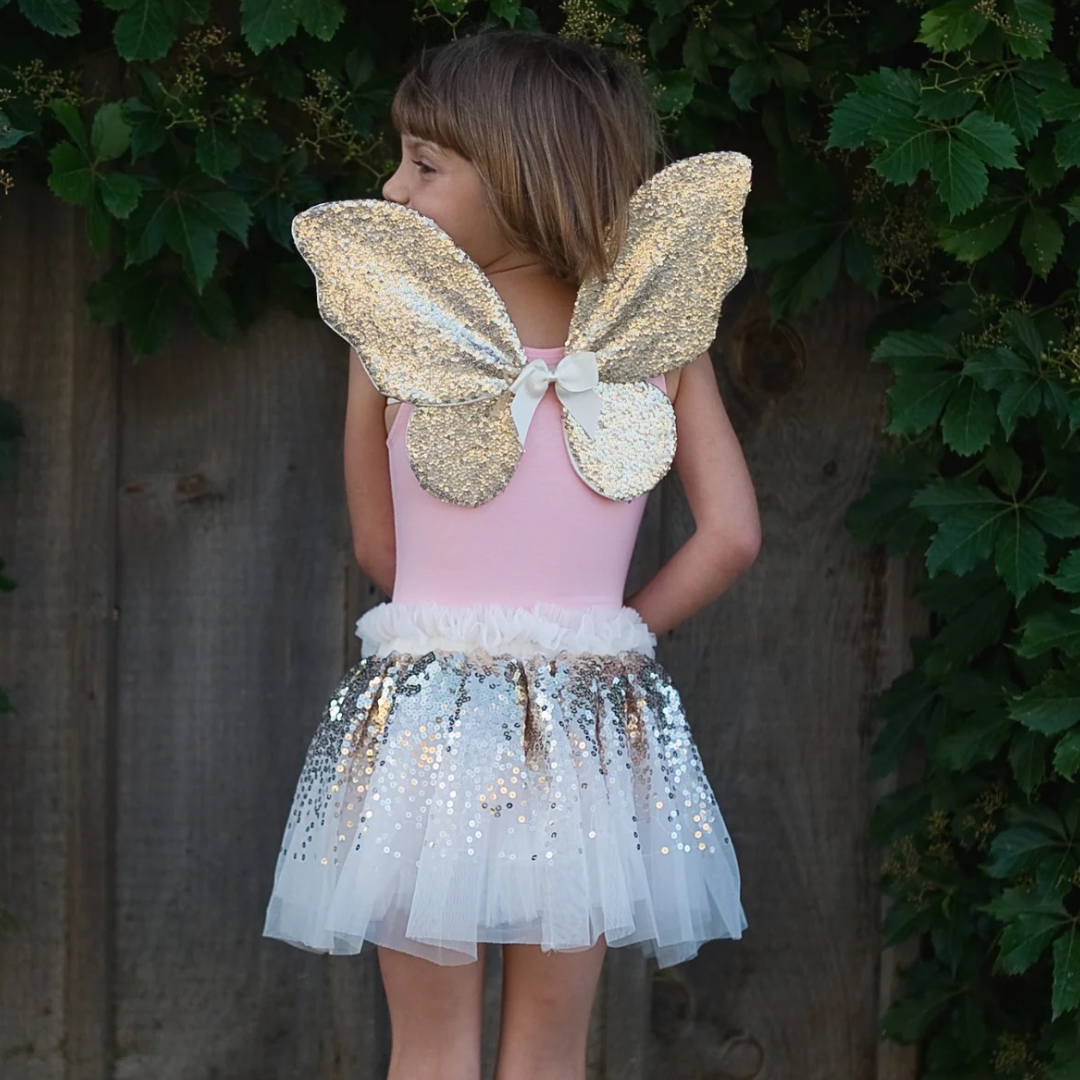 Falda de lentejuelas doradas con alas y varita